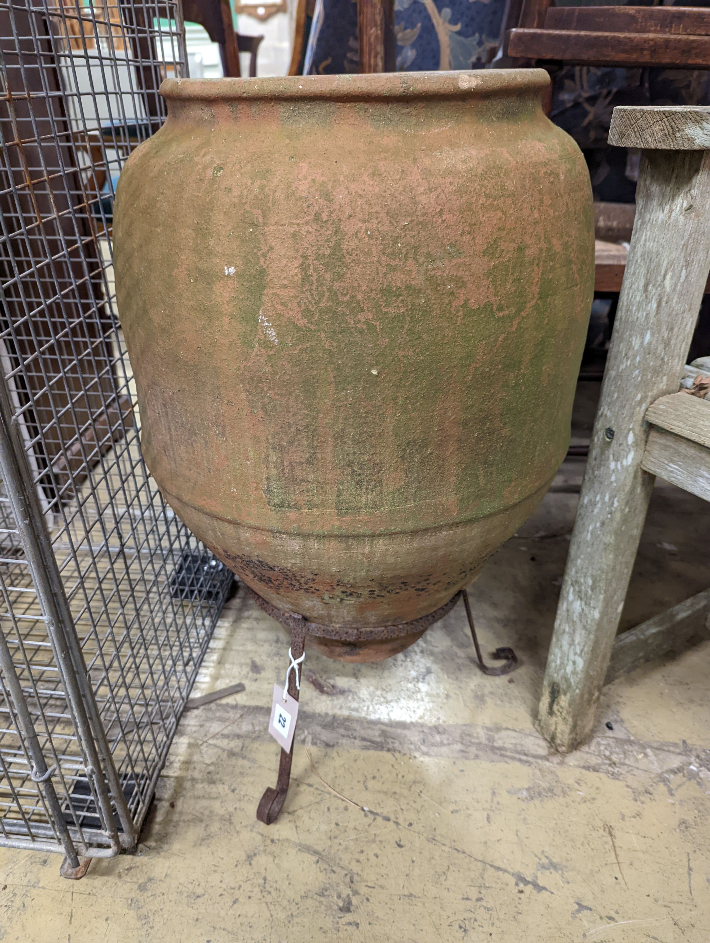 A terracotta garden urn on wrought iron stand. W-38cm, D-38cm, H-68cm.